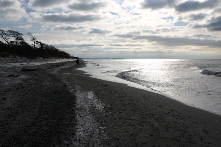 Winter beach walk beneath a dramatic cloudy sky
